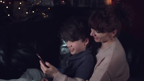 4k-Authentic-Shot-of-a-Child-with-his-Mum-Looking-in-Phone-and-Smiling