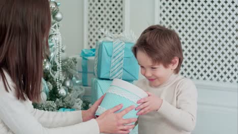 Madre-y-hijo-feliz-comprobando-regalos-sentados-cerca-del-árbol-de-Navidad