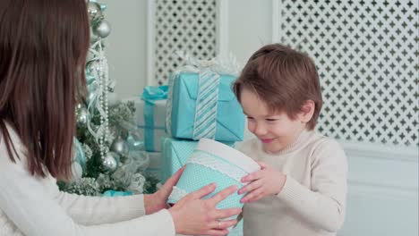 Mother-and-happy-son-checking-gifts-sitting-near-the-Christmas-tree