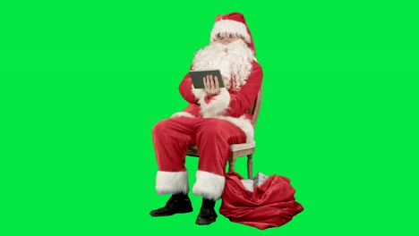 Santa-Claus-con-tablet-PC-para-navegar-por-internet-y-comunicar-en-social-media-con-los-niños-en-una-pantalla-verde-cromo-llave