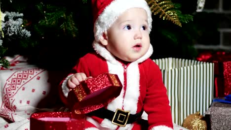 baby-in-Santa-suit,-Santa-Claus-little-boy,-child-sits-in-the-carnival-costumes,-Christmas-costumes-under-the-Christmas-tree
