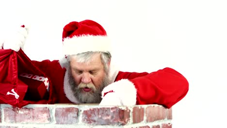 Santa-claus-placing-gift-box-into-a-chimney