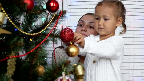 Chicas-felizes,-madre-e-hija-decorando-un-árbol-de-Navidad-en-casa.