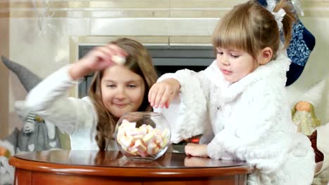 kids-steal-candy,-little-girl-hiding-under-a-table,-look-out-and-grab-candy-marshmallows,-children-with-a-sly-look