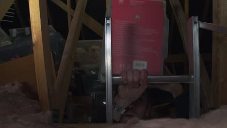 Male-carrying-box-into-attic-using-a-ladder-for-safe-keeping-and-storage