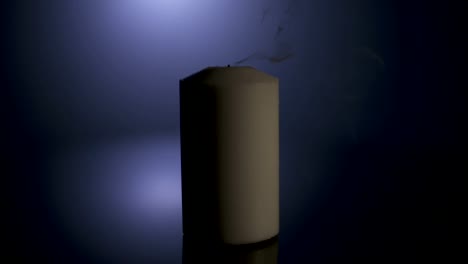 Slow-motion-macro-footage-of-a-white-candle-on-a-dark-background