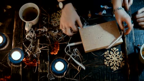 Top-view-of-young-couple-sitting-at-the-table-with-holidays-Christmas-decoration-and-opening-the-box-together