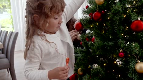 Mother-and-daughter-decorating-Christmas-tree-at-home