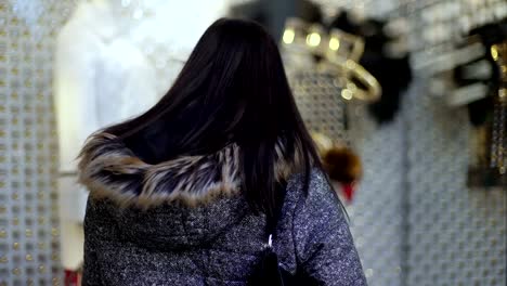 Weihnachts-shopping:-junge-Frau-hält-vor-einem-Schaufenster