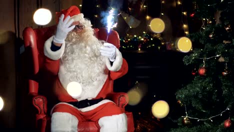 Pleasing-Santa-Clause-sits-into-his-chair-in-front-of-a-Christmas-tree.