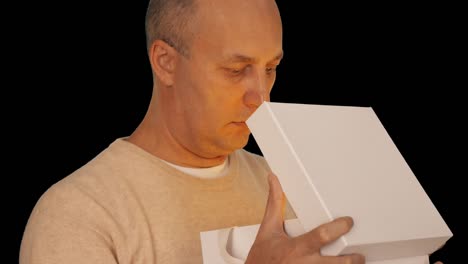 Adult-caucasian-man-in-casual-beige-sweater-get-present-open-gift-box.-Man-looking-into-gift-box-and-spot-light-at-his-face.-Close-up-head-shot.-Alpha-channel-chroma-key-transparent.