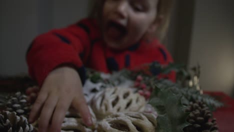 Cute-little-girl-grabbing-a-tasty-Christmas-pudding-when-no-one-is-watching