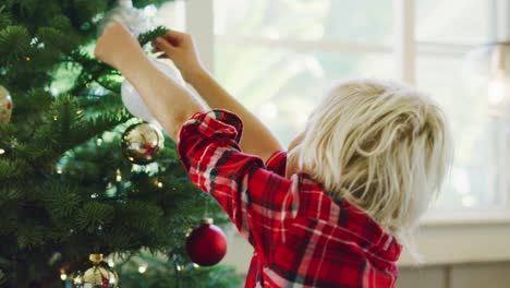 Kleiner-Junge-dekorieren-Weihnachtsbaum