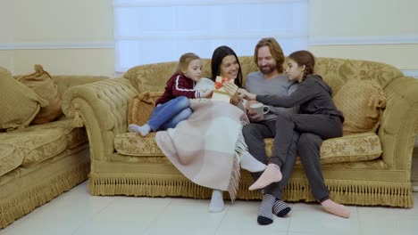 Happy-family-with-christmas-gift-at-the-sofa-at-home