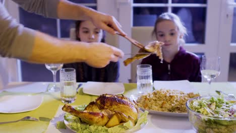 Father-put-a-chicken-thigh-on-daughter's-plate