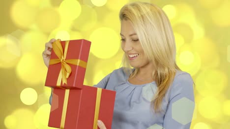 Happy-caucasian-women-take-red-gift-box-at-gold-background.-Smiling-female.-Present-surprise.