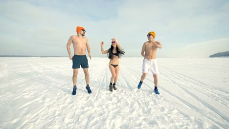 Three-friends-dance-and-jump-during-cold-training-while-wearing-swimsuits.-4K.