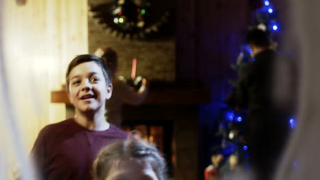 Cheerful-family-looking-through-window-in-Christmas-night