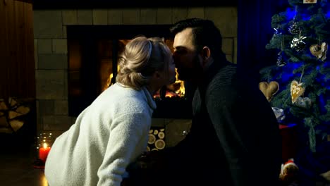 Loving-couple-at-fireplace-before-Christmas