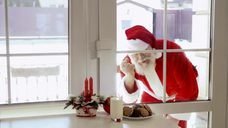 Santa-Claus-klopfen-in-Fenster-und-wollen,-dass-Milch-und-Kekse-schmecken