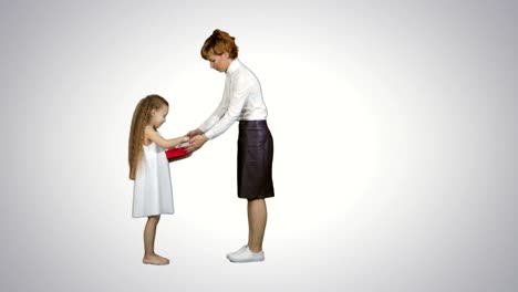 Beautiful-young-mom-giving-a-present-to-her-charming-little-girl-on-white-background