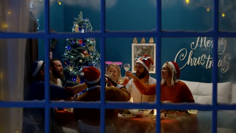 View-through-window-of-people-celebrating-Christmas