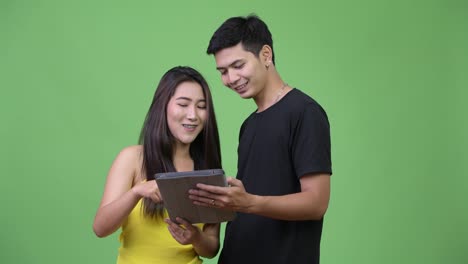 Young-Asian-couple-using-digital-tablet-together