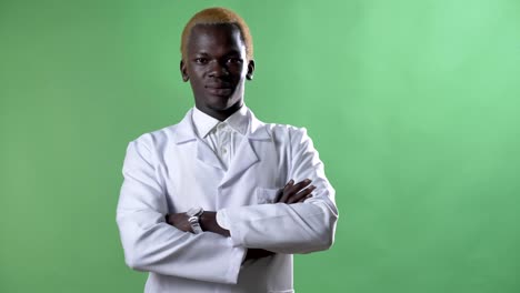 Young-african-blond-doctor-in-white-coat-and-glasses-looking-at-camera,-standing-alone-on-chromakey-background,-confident-and-successful