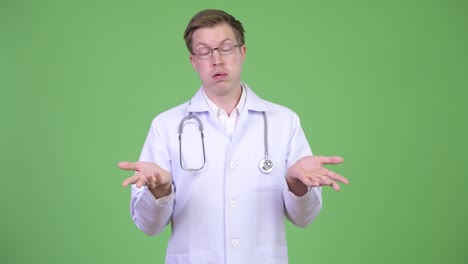 Portrait-Of-Young-Man-Doctor-Shrugging-Shoulders