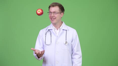 Portrait-Of-Young-Man-Doctor-Playing-With-Red-Apple