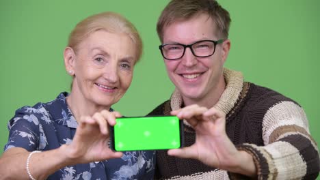 Happy-grandmother-and-grandson-showing-phone-together