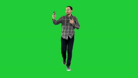 Mann-am-Telefon-im-Gespräch-mit-jemandem-winken-Hallo-während-Videochat-Unterhaltung-auf-einem-Green-Screen,-Chroma-Key-per-Videoanruf-anrufen