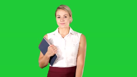 Beautiful-young-woman-with-notebooks-walking-on-a-Green-Screen,-Chroma-Key