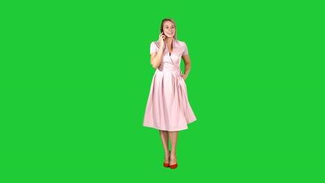 Happy-smiling-woman-talking-on-cell-phone-while-walking-on-a-Green-Screen,-Chroma-Key