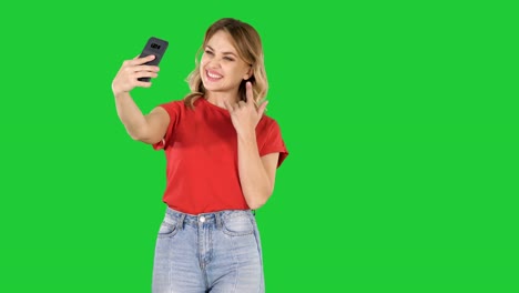 Cute-girl-making-selfie-walking-on-a-Green-Screen,-Chroma-Key