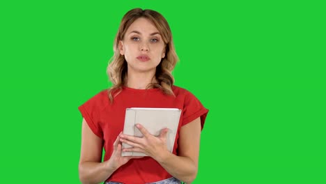 Dame-mit-roten-T-shirt,-eine-Tablette-in-ihren-Händen-hält,-mit-einem-ernsten-Gesicht-Gespräch-mit-Kamera-auf-einem-Green-Screen,-Chroma-Key