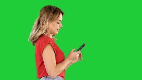 Happy-cute-beautiful-young-woman-play-games-by-mobile-phone-on-a-Green-Screen,-Chroma-Key