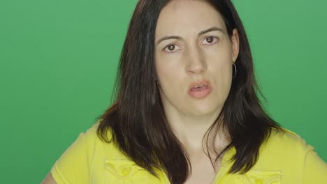 Young-brunette-woman-looking-really-upset,-on-a-green-screen-studio-background