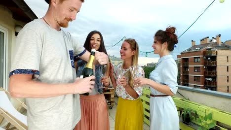 Side-view-of-hipster-man-opening-champagne,-female-friends-waiting-with-glasses