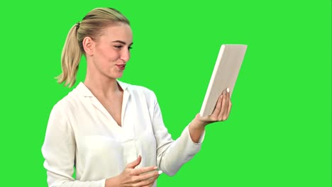 Positive-Geschäftsfrau-ist-auf-der-Skype-Gespräch-mit-Partner-auf-Tablet-auf-einem-Green-Screen,-Chroma-Key