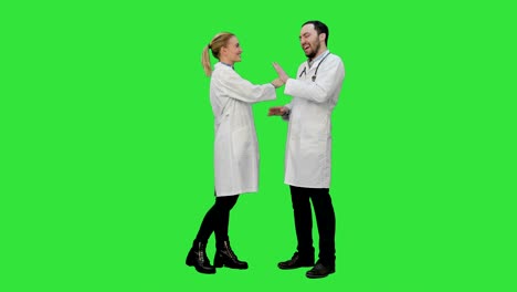 Funny-male-doctor-kidding-on-female-nurse-give-a-false-hi-five-on-a-Green-Screen,-Chroma-Key