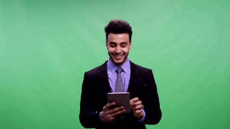 Cheerful-Businessman-Hold-Tablet-Computer-Over-Chroma-Key-Chatting-Online-Green-Screen-Happy-Smiling-Young-Latin-Business-Man