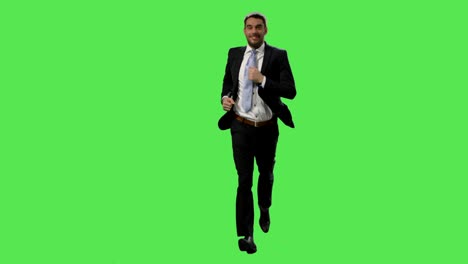 Happy-businessman-in-a-suit-is-running-on-a-mock-up-green-screen-in-the-background.