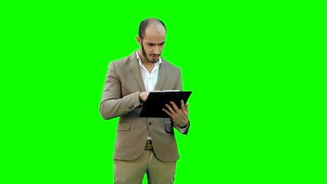 Concentrated-businessman-reading-financial-report-on-a-Green-Screen,-Chroma-Key