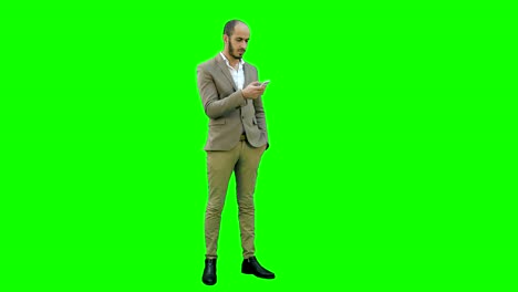 Empresario-con-teléfono-móvil-en-una-pantalla-verde-Chroma-Key