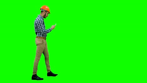 Bauingenieur-im-Helm-mit-Handy-auf-einem-Green-Screen,-Chroma-Key