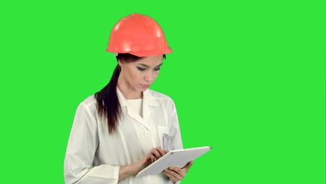 Female-engineer-in-helmet-using-tablet-computer-on-a-Green-Screen,-Chroma-Key