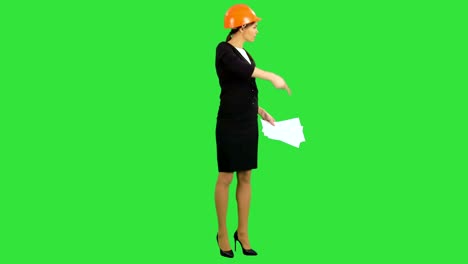 Angry-female-construction-supervisor-holding-documents-and-shouting-at-workers-on-a-Green-Screen,-Chroma-Key