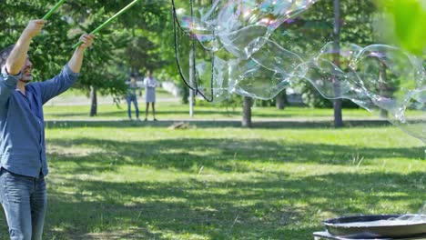 Little-Boys-Catching-Huge-Soap-Bubble-Made-by-Performer