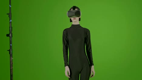 Attraktives-Mädchen-junge-Mode-Modell-tragen-eine-VR-Kopfhörer-in-green-Screen-gedreht